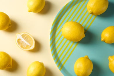 Flat lay composition with ripe lemons on color background