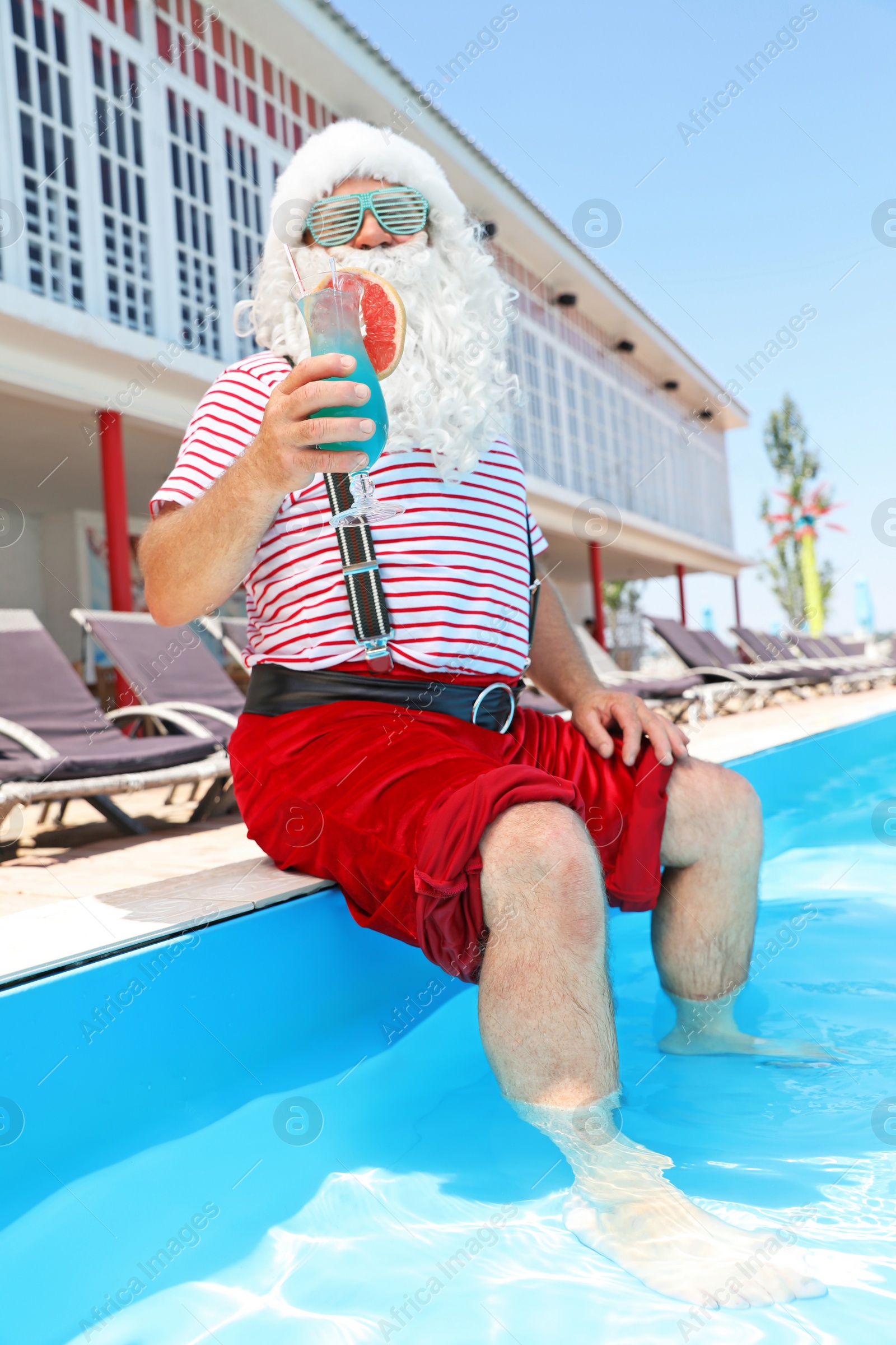 Photo of Authentic Santa Claus with cocktail near pool at resort
