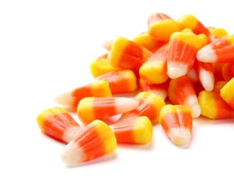 Photo of Colorful candy corns for Halloween party on white background
