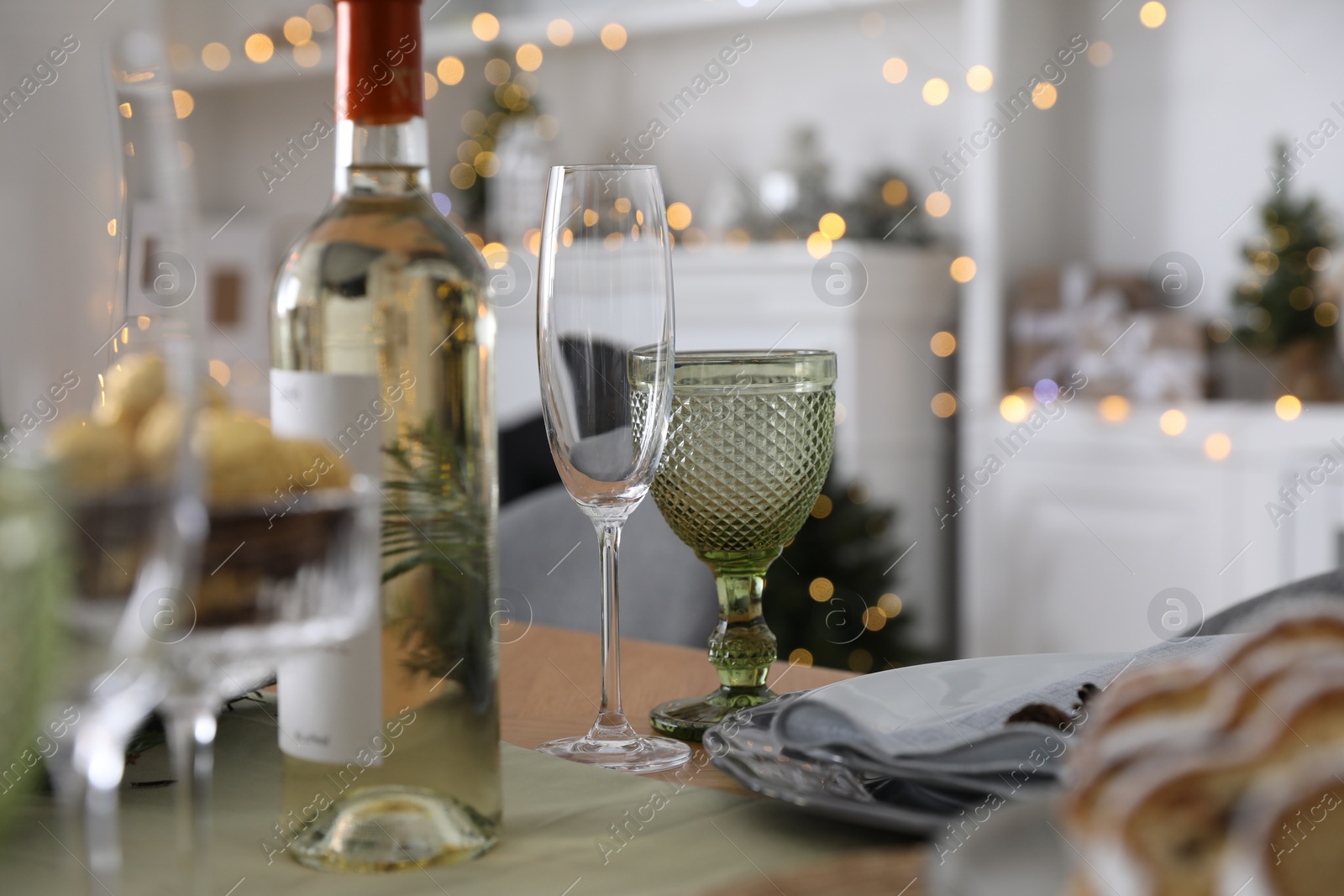 Photo of Christmas table setting with bottle of wine and dishware