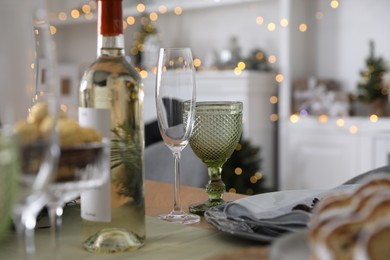 Photo of Christmas table setting with bottle of wine and dishware