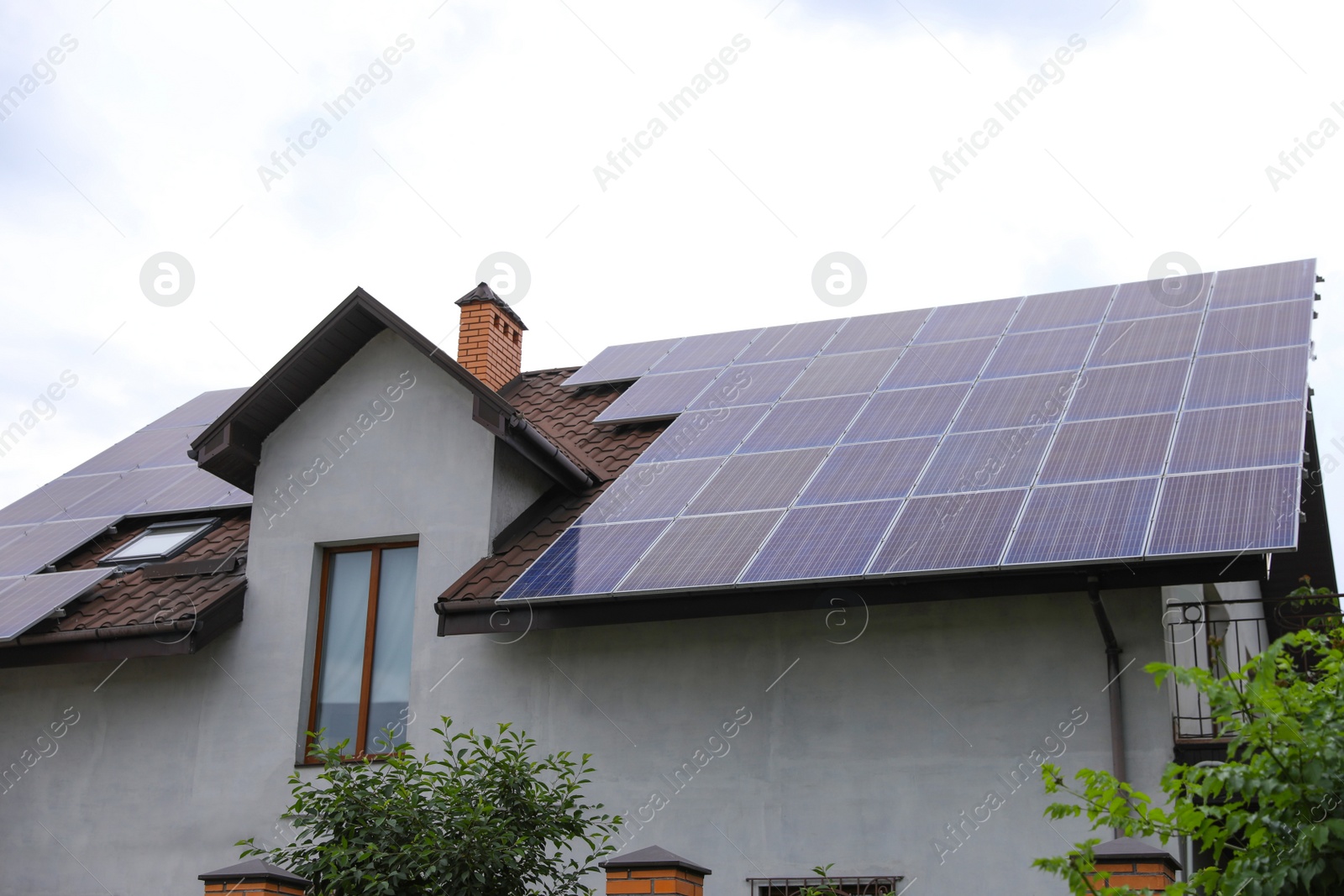 Photo of House with installed solar panels on roof. Alternative energy source