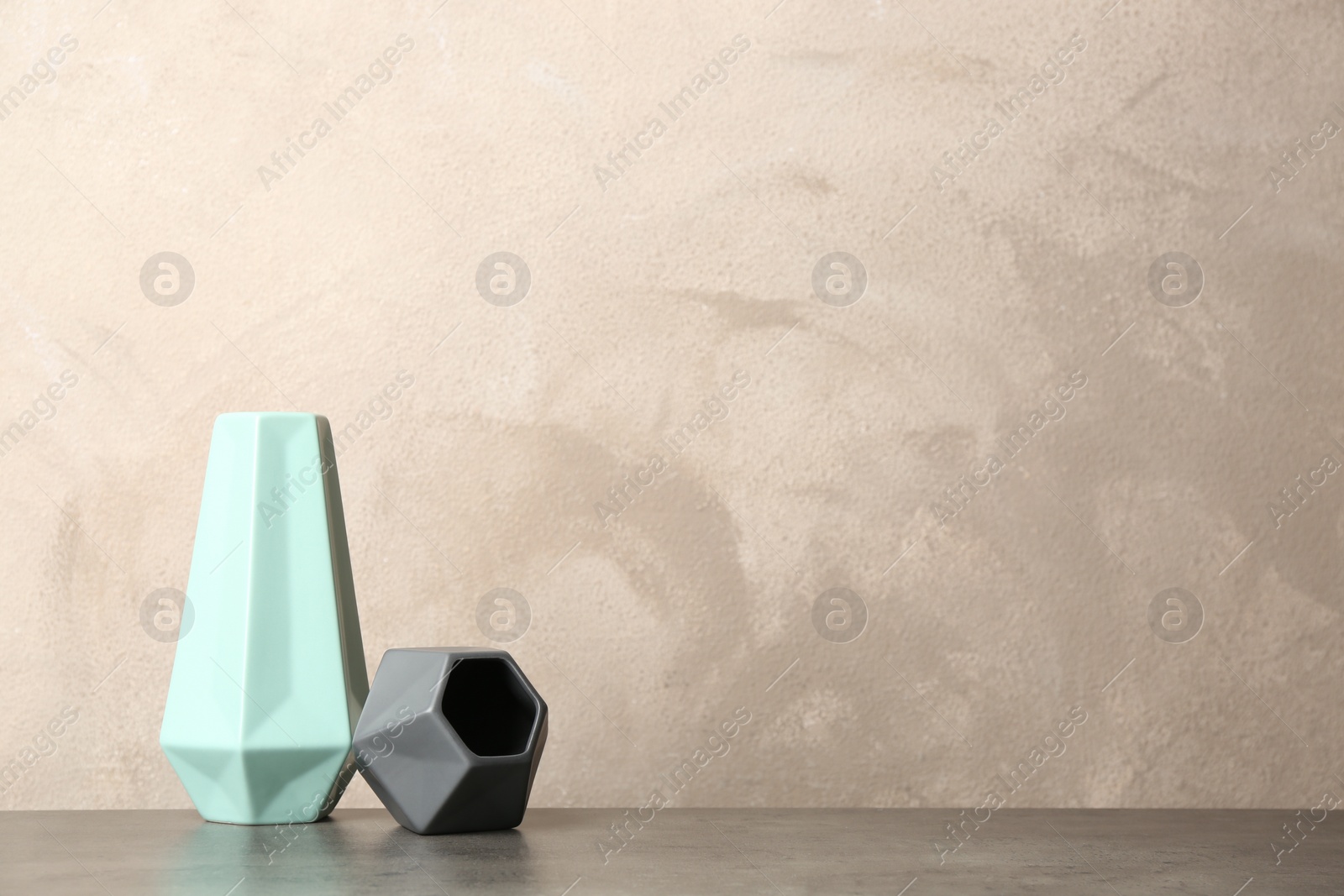 Photo of Stylish ceramic vases on grey stone table. Space for text