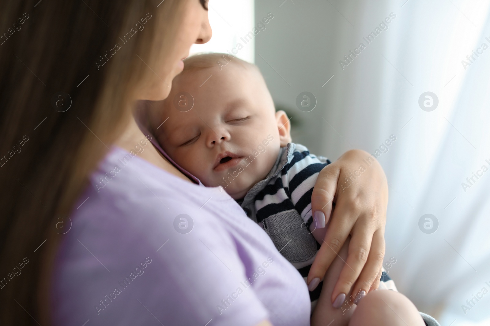 Photo of Mother with her sleeping baby at home, closeup view