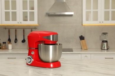 Photo of Modern red stand mixer on white marble table in kitchen, space for text