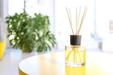 Reed freshener on table in light room, closeup