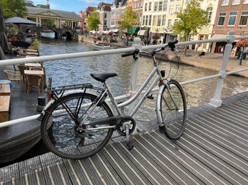 Beautiful view of bicycle on pedestrian bridge near canal in city