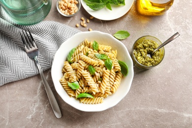 Photo of Plate of delicious basil pesto pasta served for dinner on table, flat lay