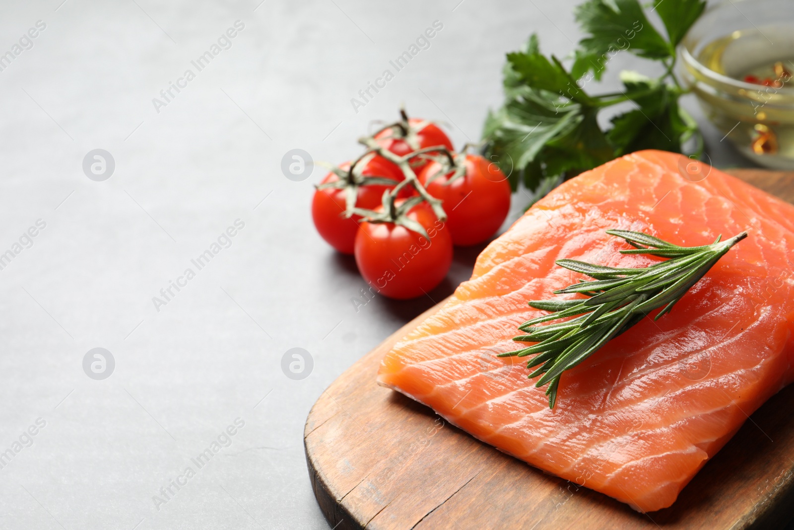 Photo of Fresh raw salmon and ingredients for marinade on light table. Space for text