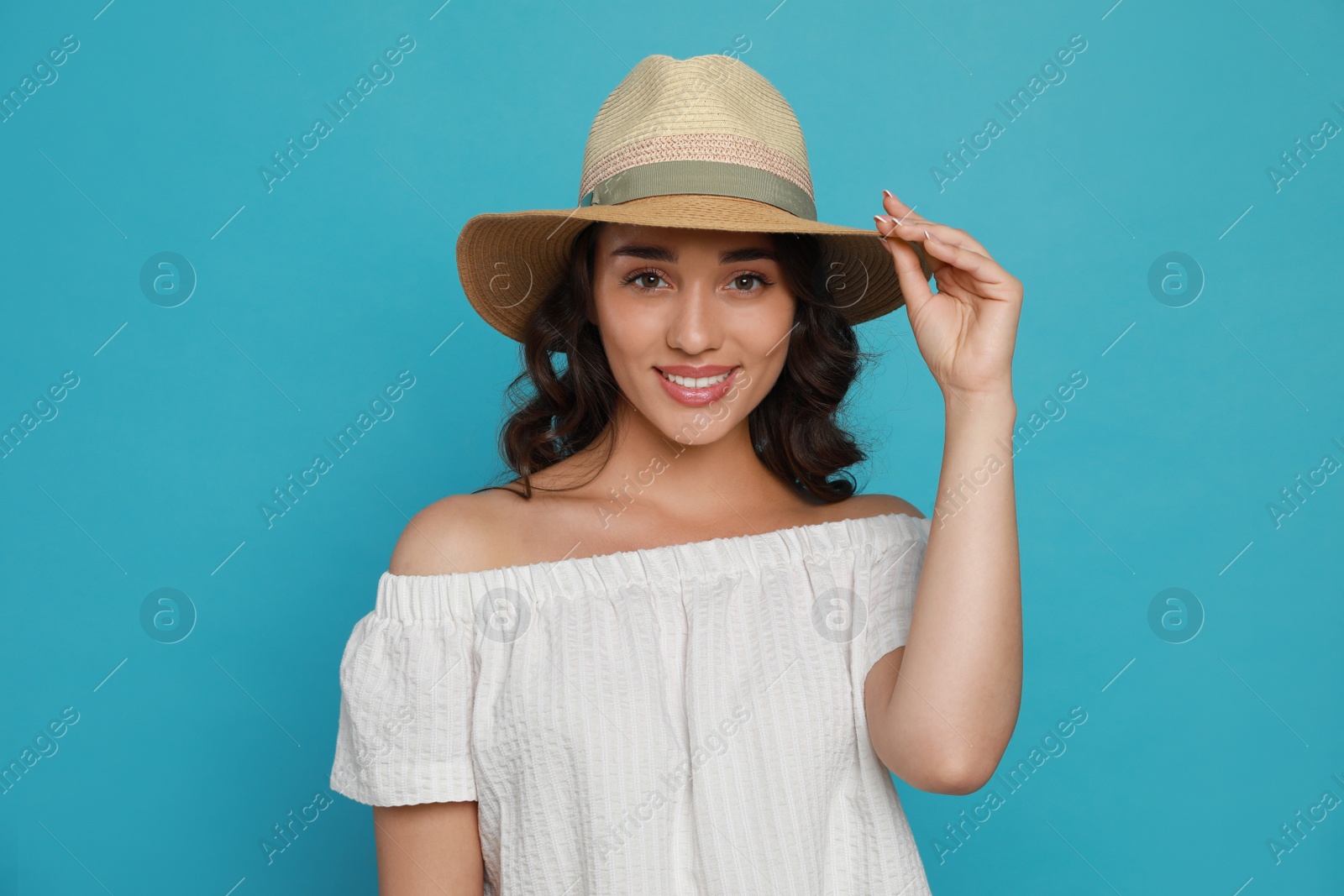 Photo of Beautiful young woman with straw hat on light blue background