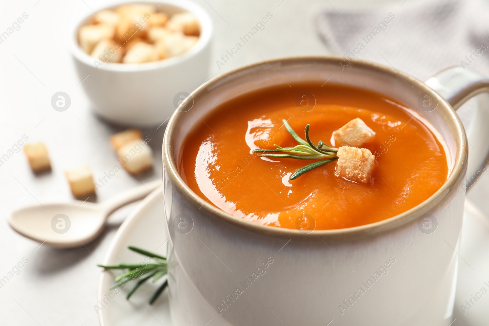 Photo of Mug of tasty sweet potato soup on table, closeup