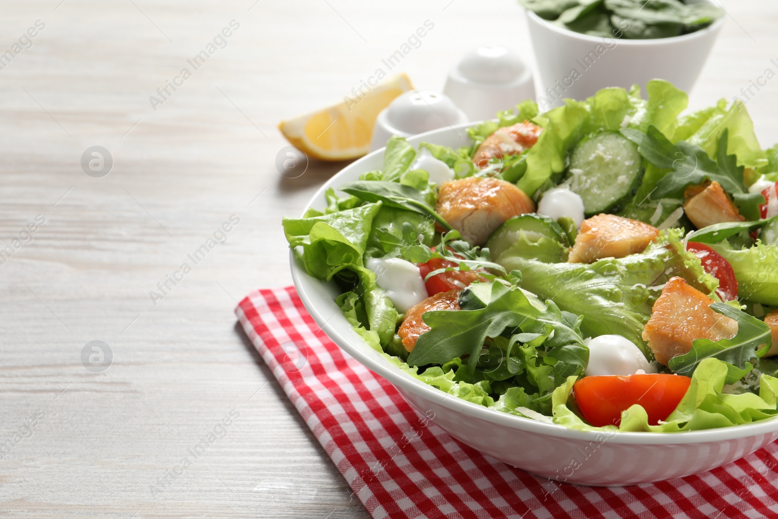 Photo of Delicious salad with chicken and vegetables on wooden table, closeup. Space for text