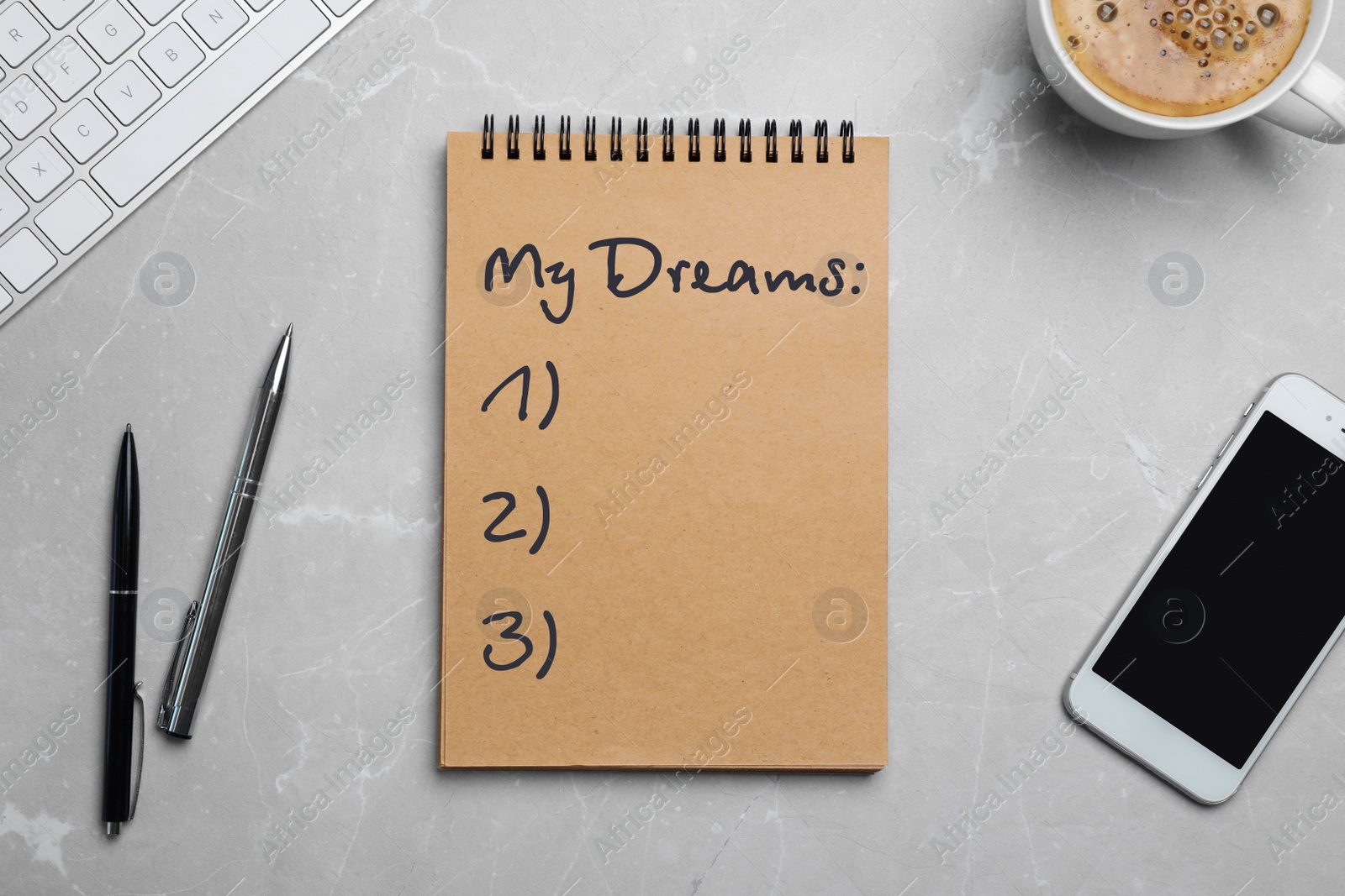 Image of Notebook with dreams list on grey marble table, flat lay 
