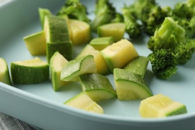 Photo of Pieces of boiled broccoli and squash on table, closeup. Child's food