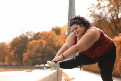 Photo of Beautiful overweight woman doing sport exercises in park