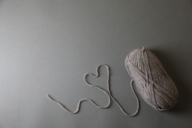 Photo of Heart made of soft yarn on light grey background, top view with space for text. Knitting textile