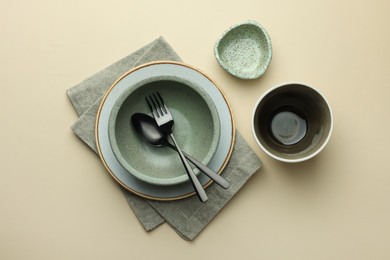 Photo of Stylish empty dishware and cutlery on beige background, flat lay