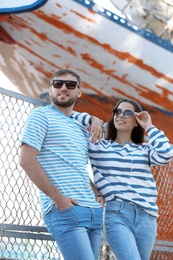 Young hipster couple in stylish jeans on pier