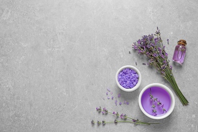 Photo of Flat lay composition with natural cosmetic products and lavender flowers on grey stone background. Space for text