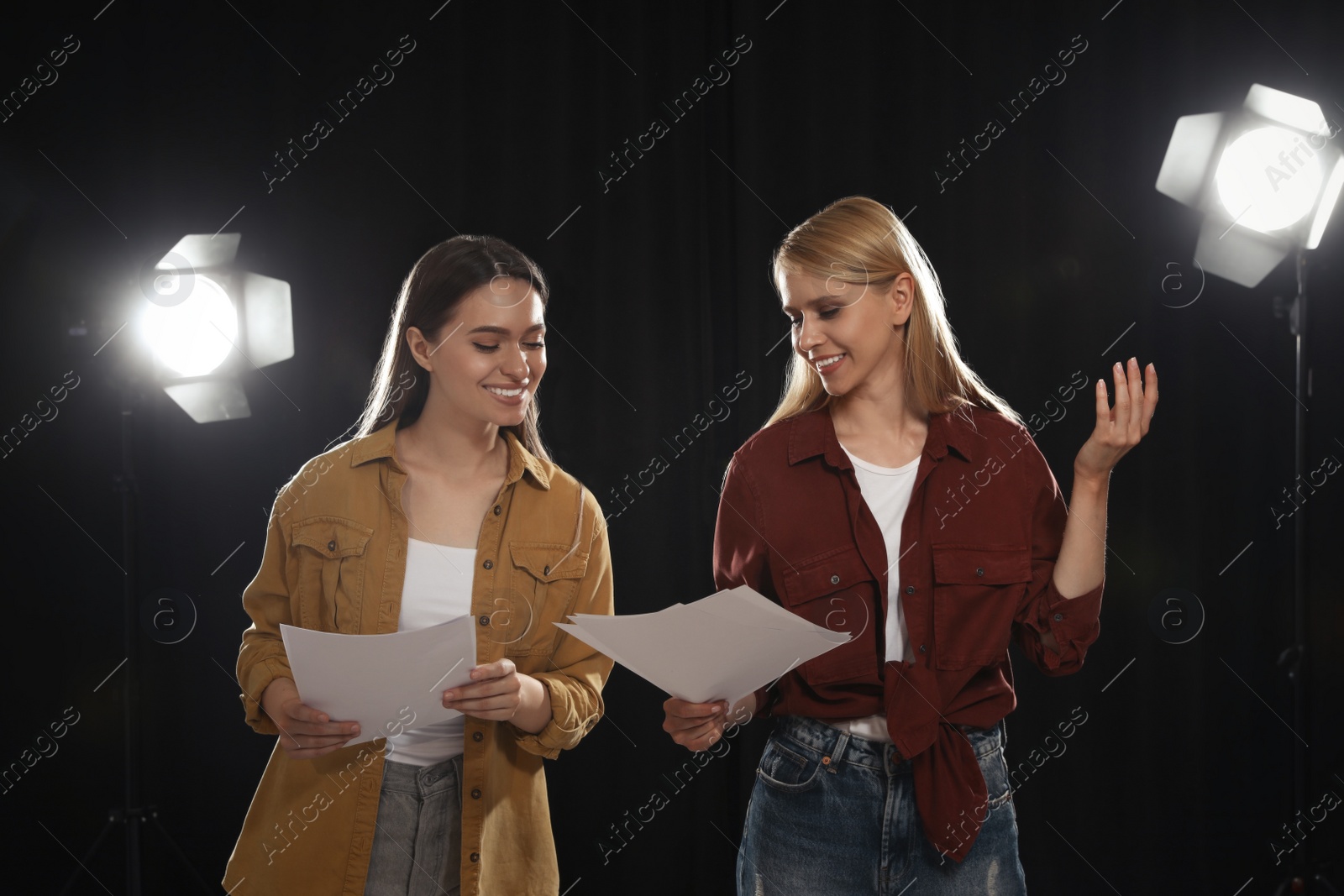 Photo of Professional actresses reading their scripts during rehearsal in theatre