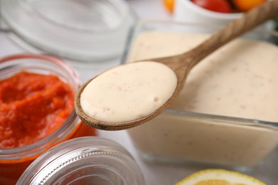 Photo of Spoon with fresh marinade over table, closeup