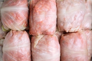 Photo of Uncooked stuffed cabbage rolls as background, top view