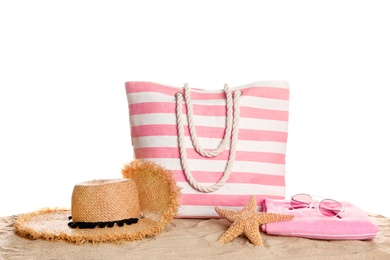 Photo of Stylish striped bag and beach accessories on sand against white background