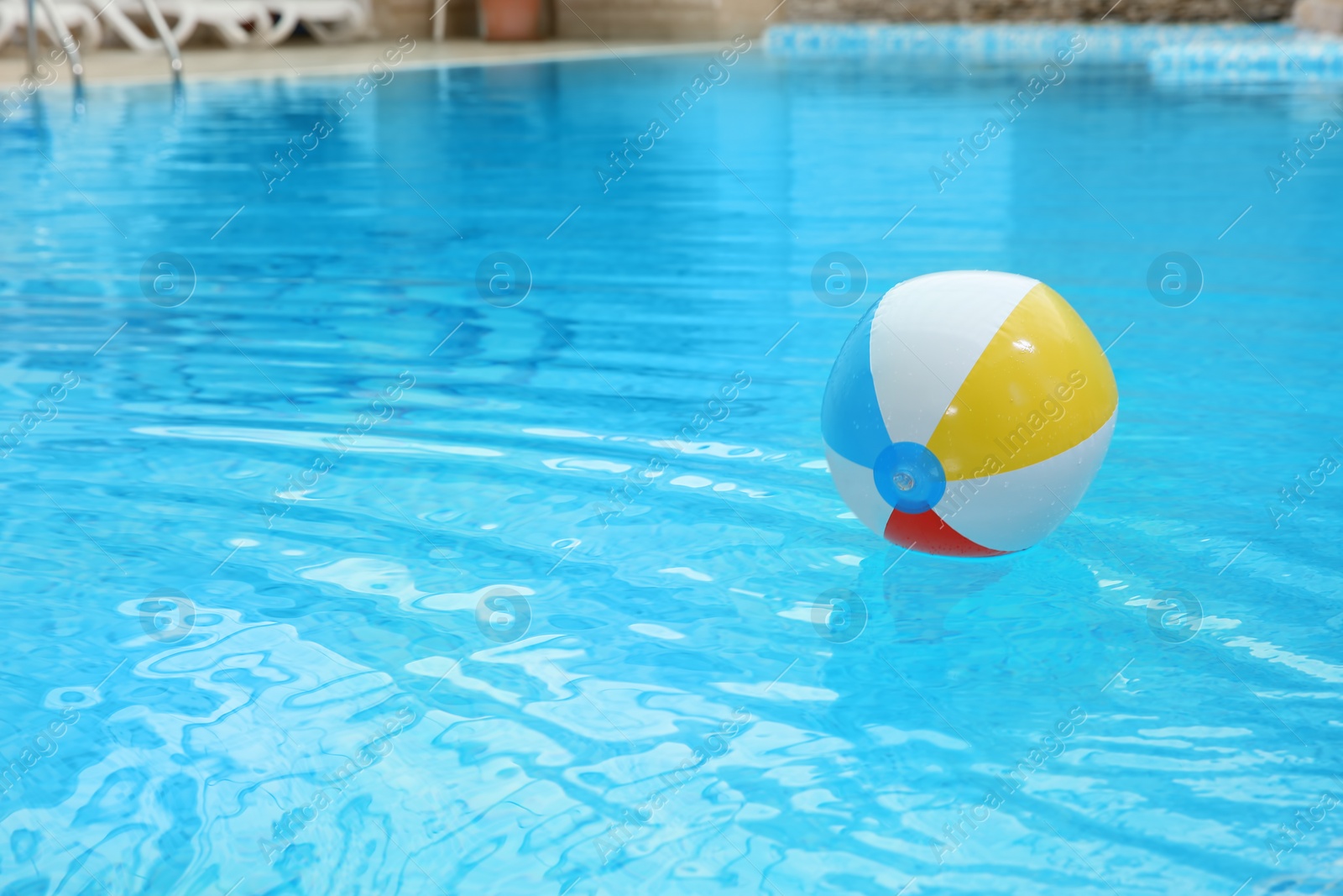 Photo of Colorful inflatable ball floating on water in swimming pool