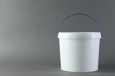 One plastic bucket with lid on grey background. Space for text