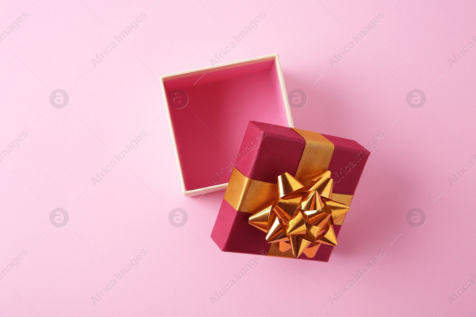 Photo of Open empty gift box on pink background, flat lay