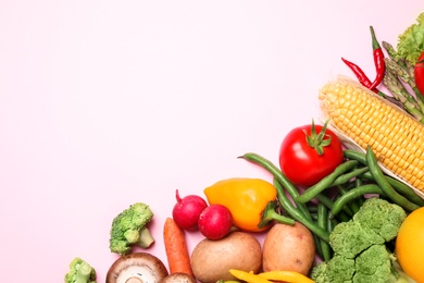 Photo of Flat lay composition with fresh vegetables on light pink background. Space for text