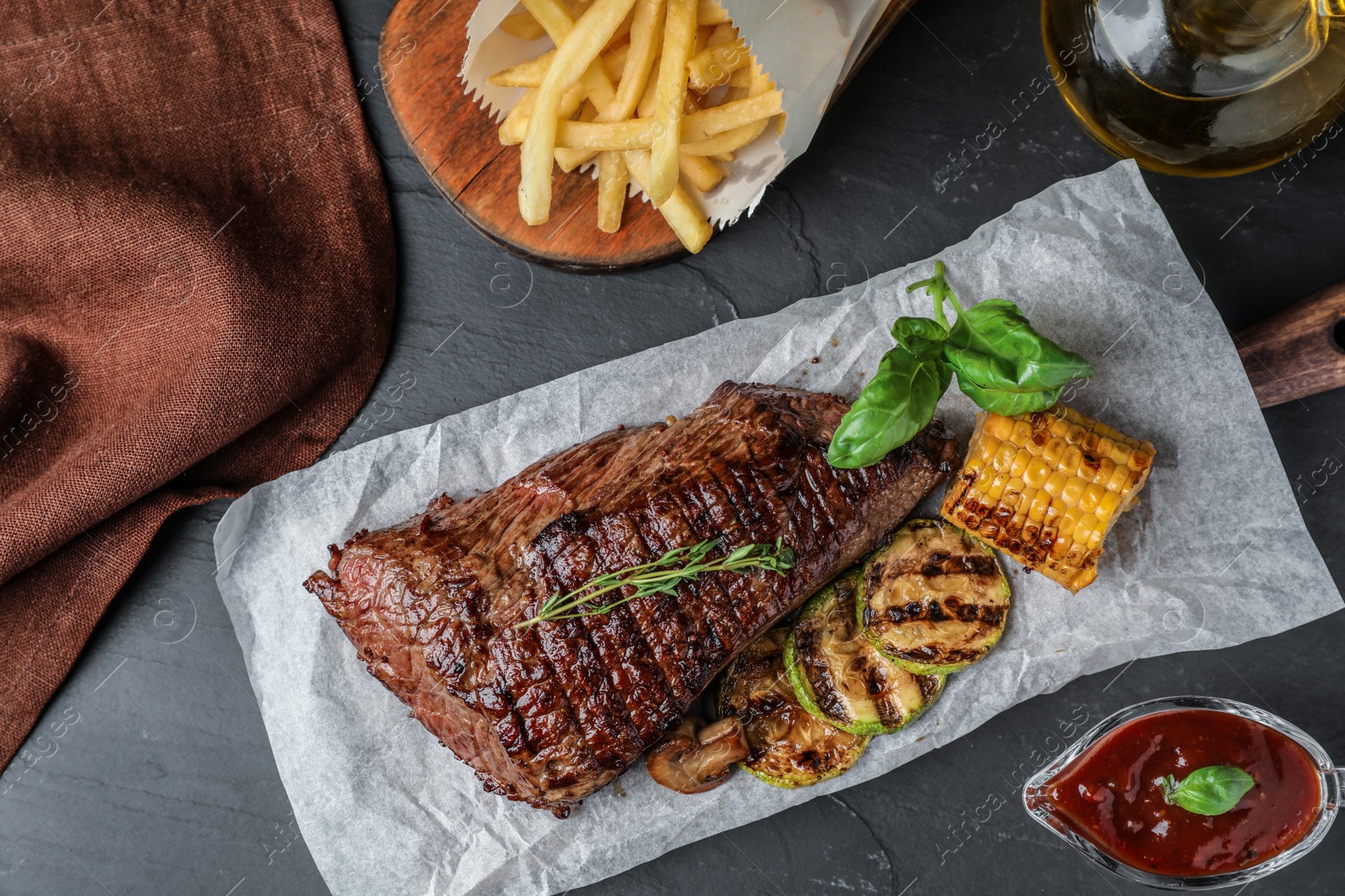 Photo of Delicious beef tenderloin served on grey table, flat lay