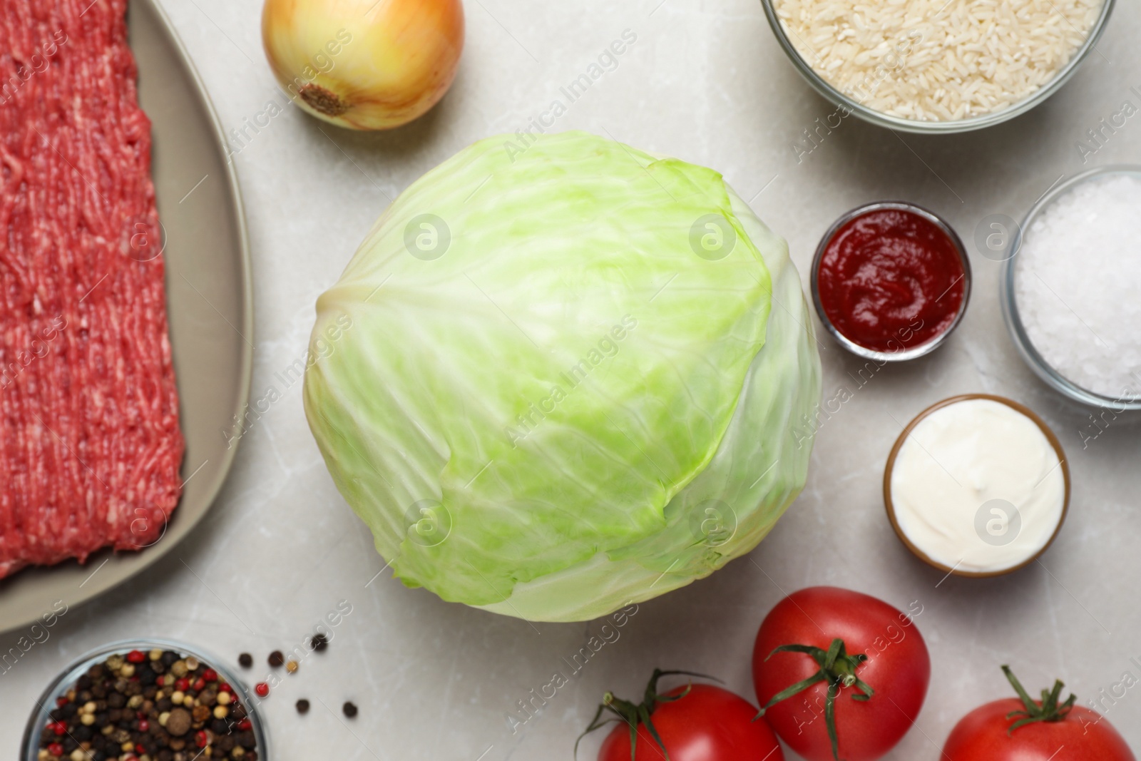 Photo of Set of ingredients for preparing stuffed cabbage rolls on light table, flat lay