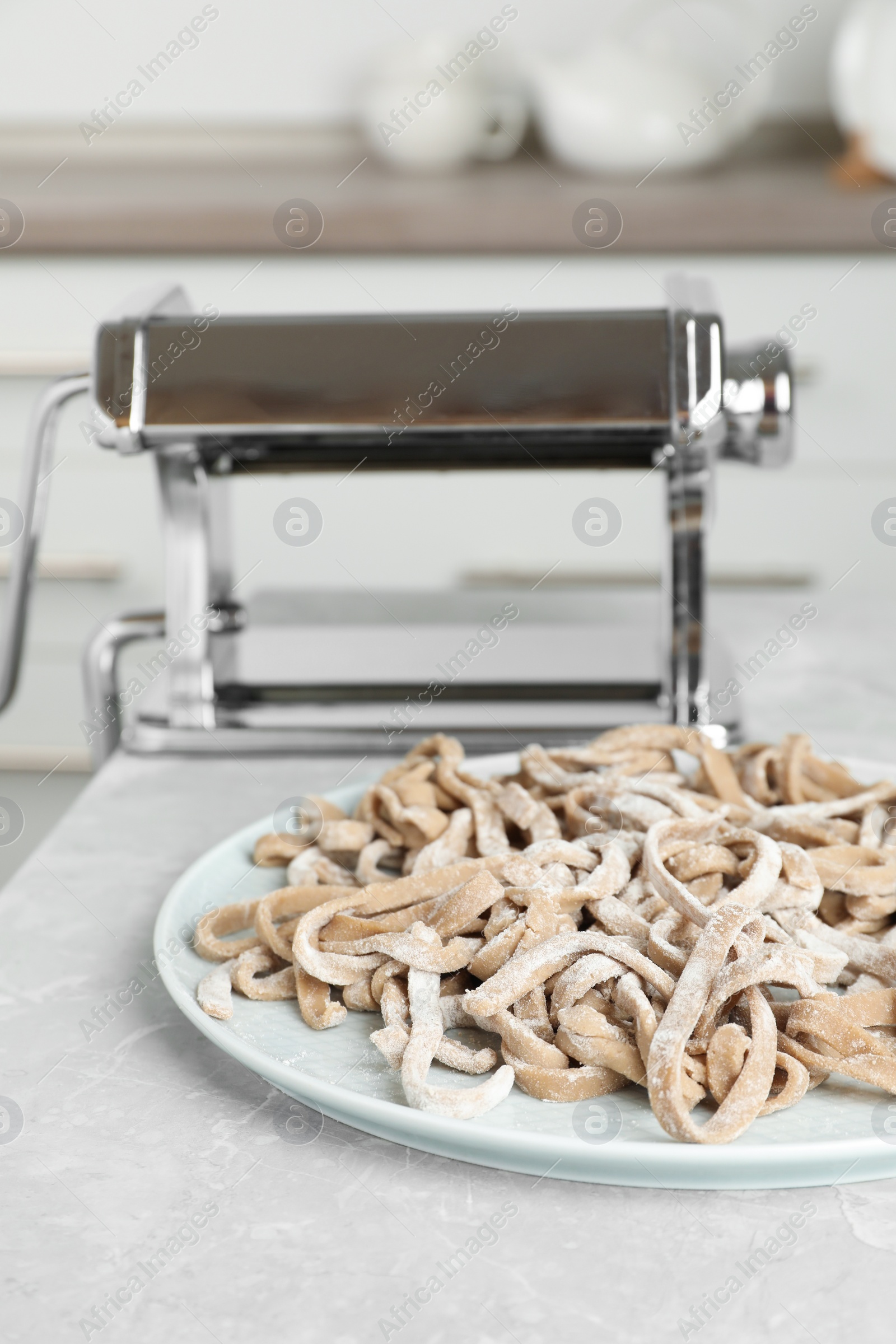 Photo of Uncooked homemade soba (buckwheat noodles) on grey table in kitchen