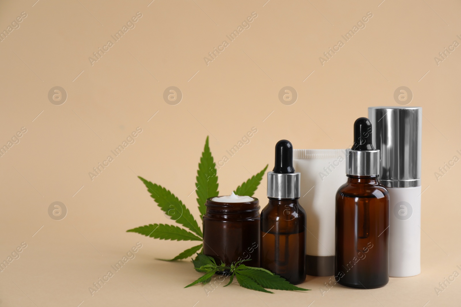 Photo of Composition with CBD oil, THC tincture and hemp leaves on beige background. Space for text