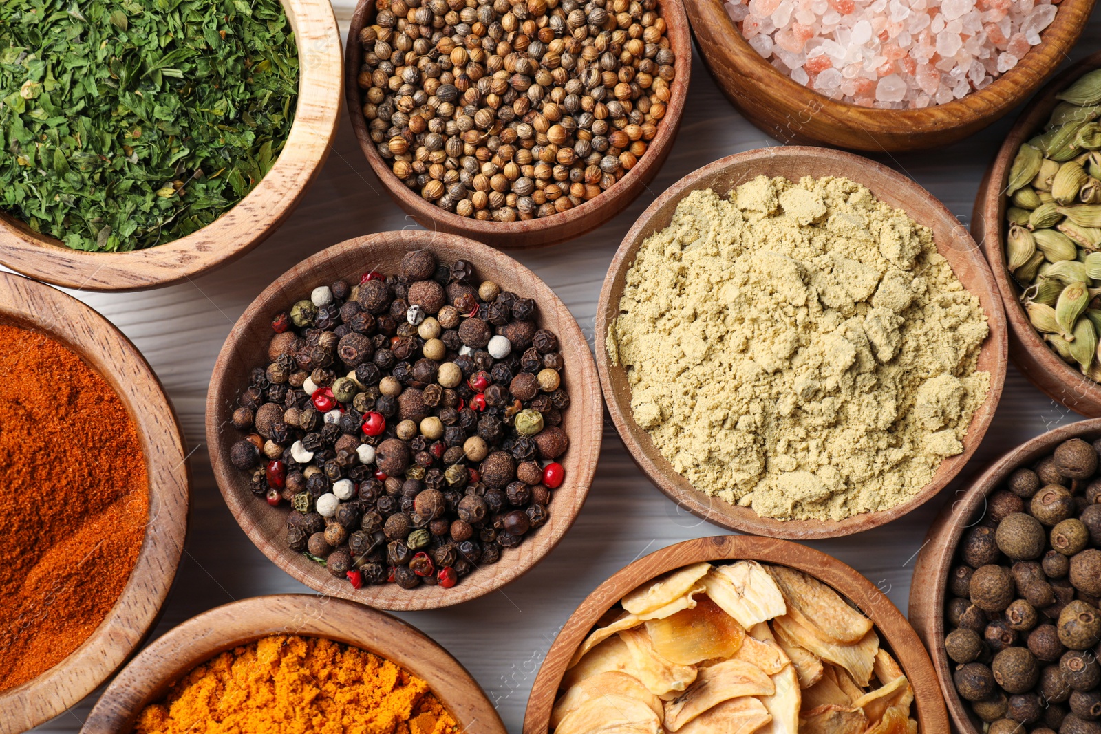 Photo of Bowls with different spices on white wooden table, top view