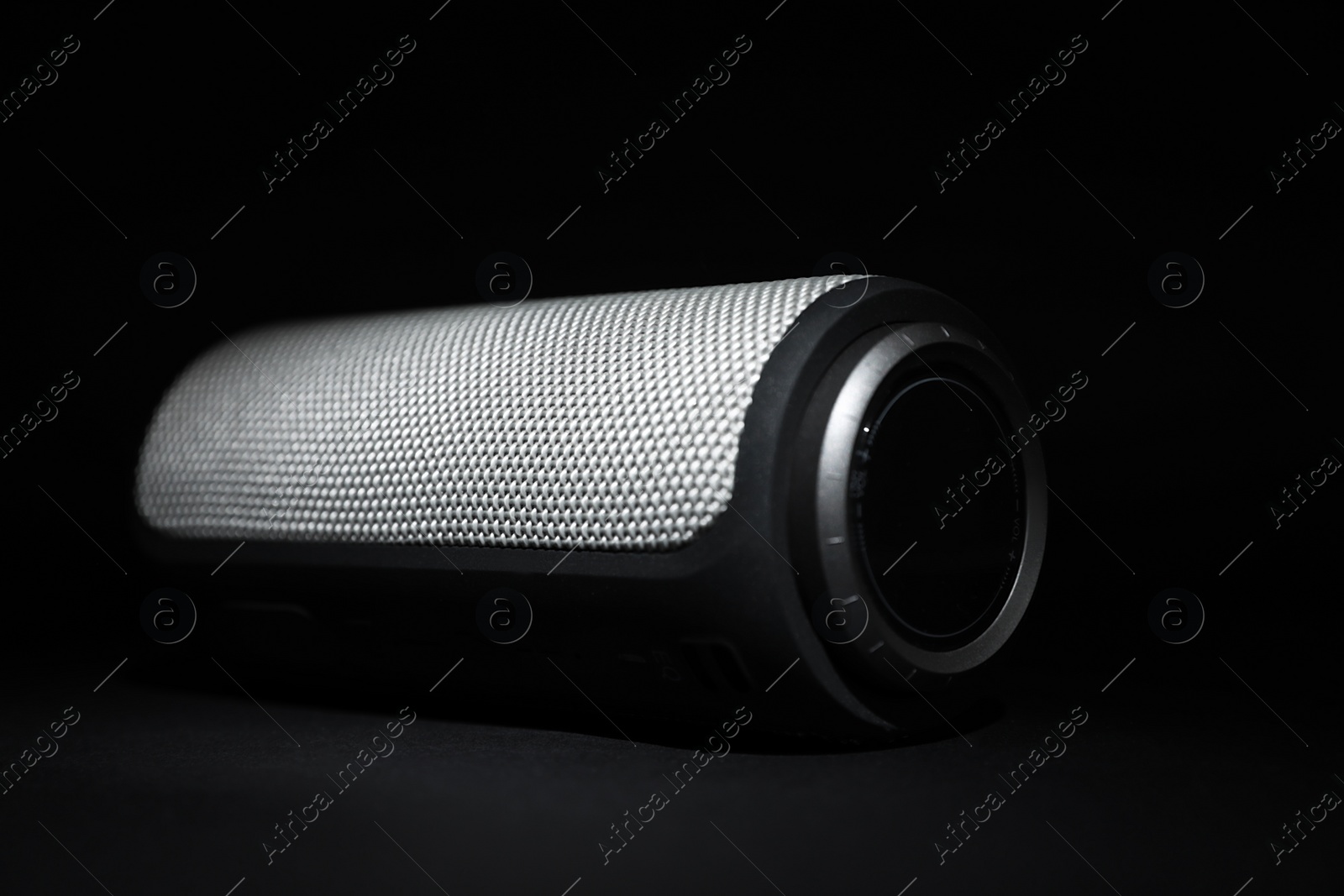 Photo of One portable bluetooth speaker on black background, closeup. Audio equipment