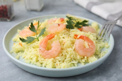 Photo of Delicious risotto with shrimps and parsley on light grey table, closeup