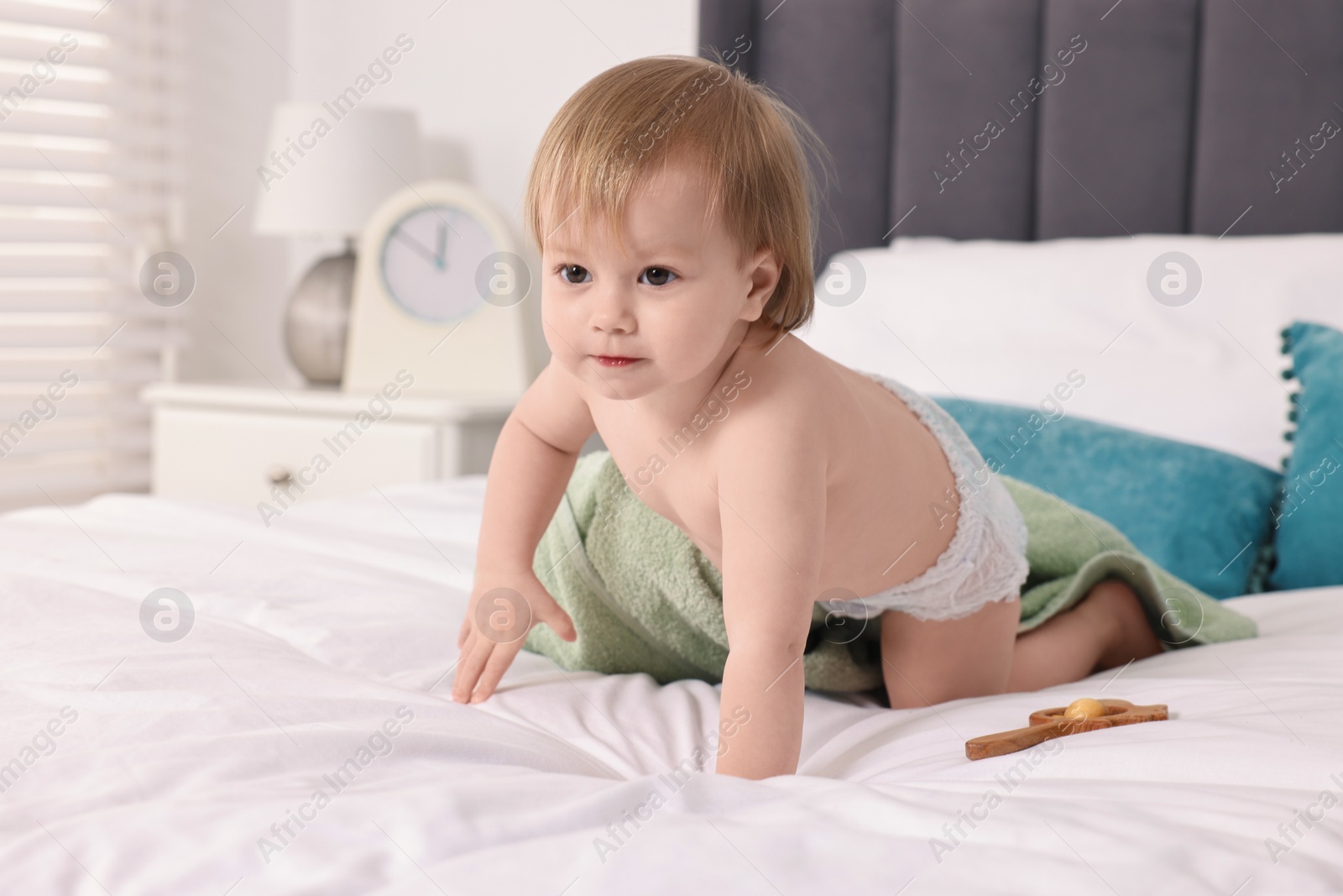 Photo of Cute little baby with towel after bathing on bed