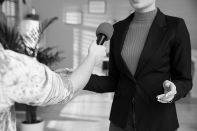 Image of Businesswoman giving interview to journalist indoors, closeup. Black and white effect