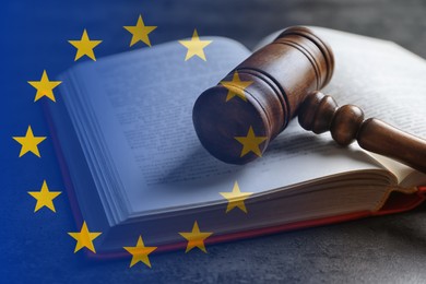 Image of Double exposure of European union flag and book with wooden gavel on grey table