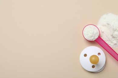 Photo of Flat lay of powdered infant formula with scoop and pacifier on beige background, space for text. Baby milk