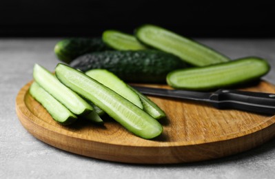 Photo of Whole and cut fresh ripe cucumbers on grey table