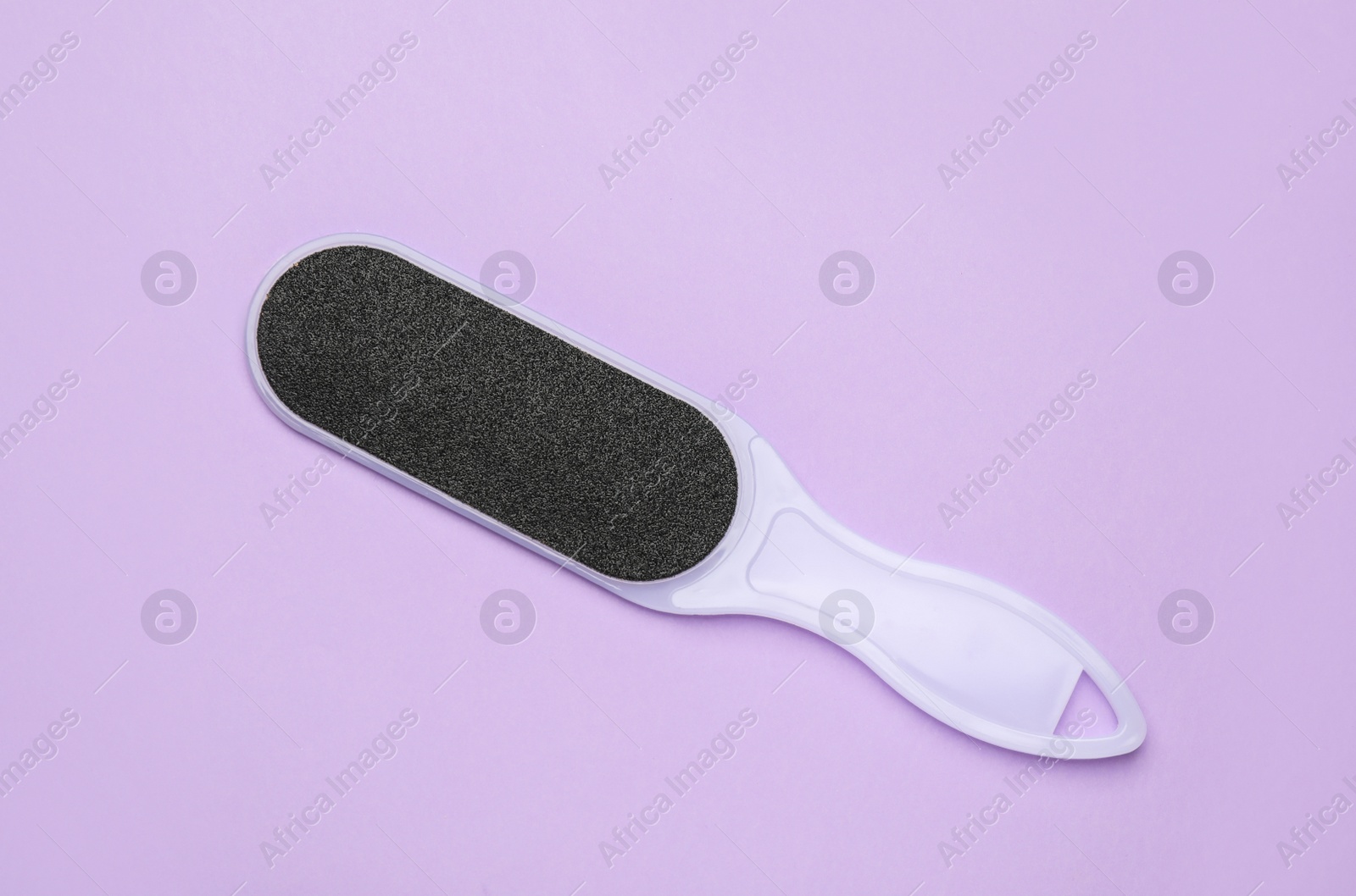 Photo of Foot file on violet background, top view. Pedicure tool