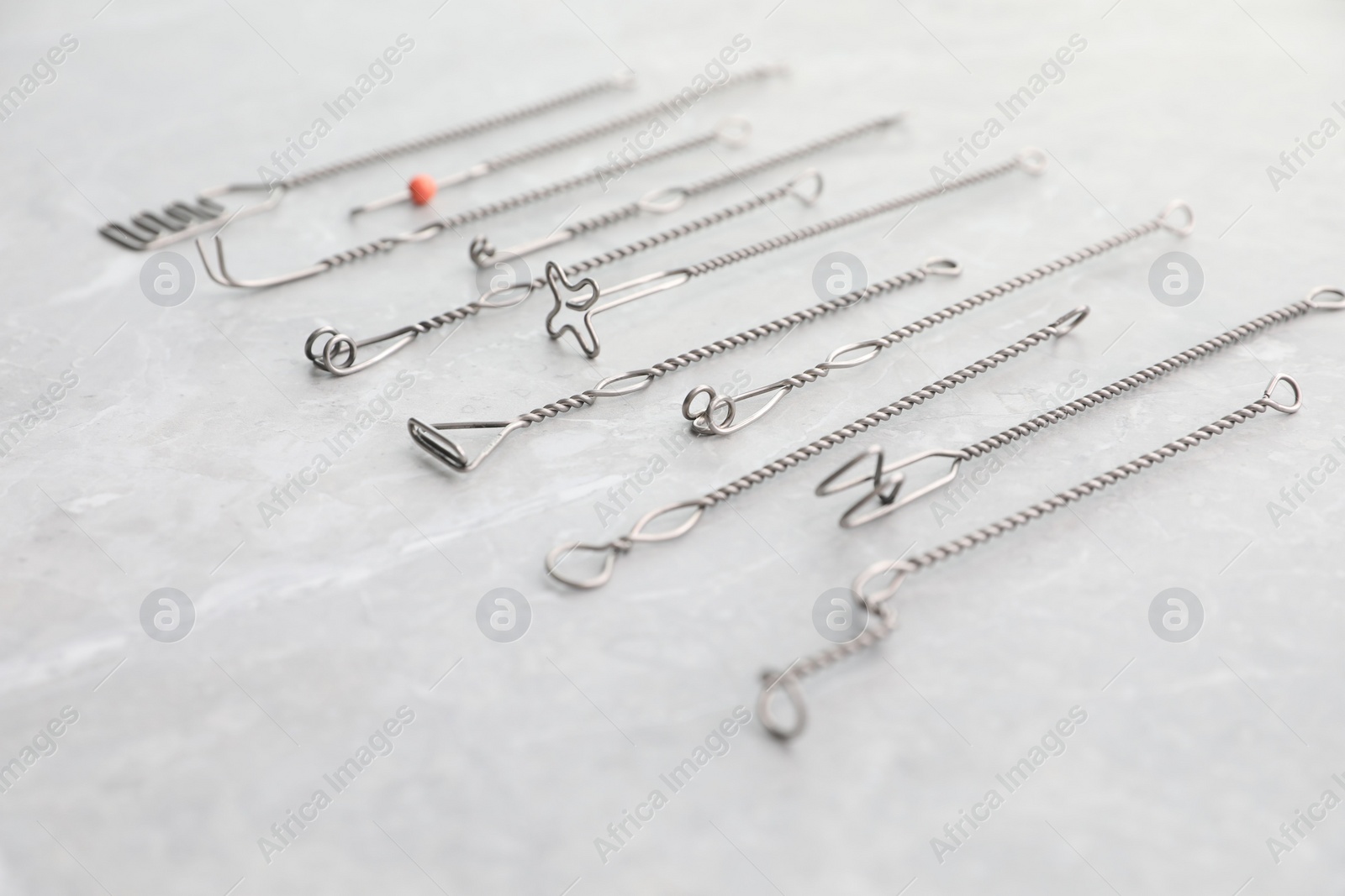 Photo of Set of different logopedic probes on marble table. Speech therapist's tools