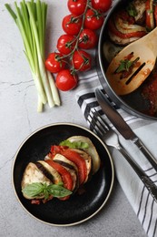 Photo of Delicious ratatouille served with basil on light grey table, flat lay