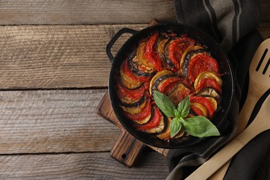 Photo of Delicious ratatouille and spatula on wooden table, top view. Space for text