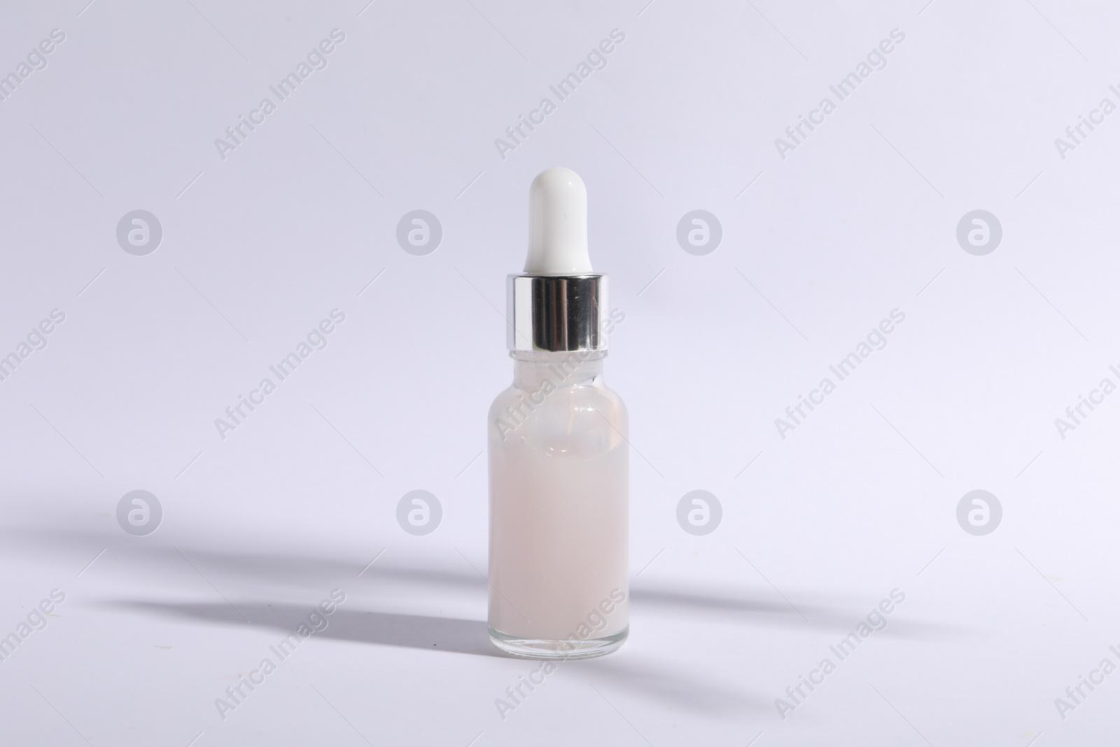 Photo of Bottle of cosmetic serum on white background