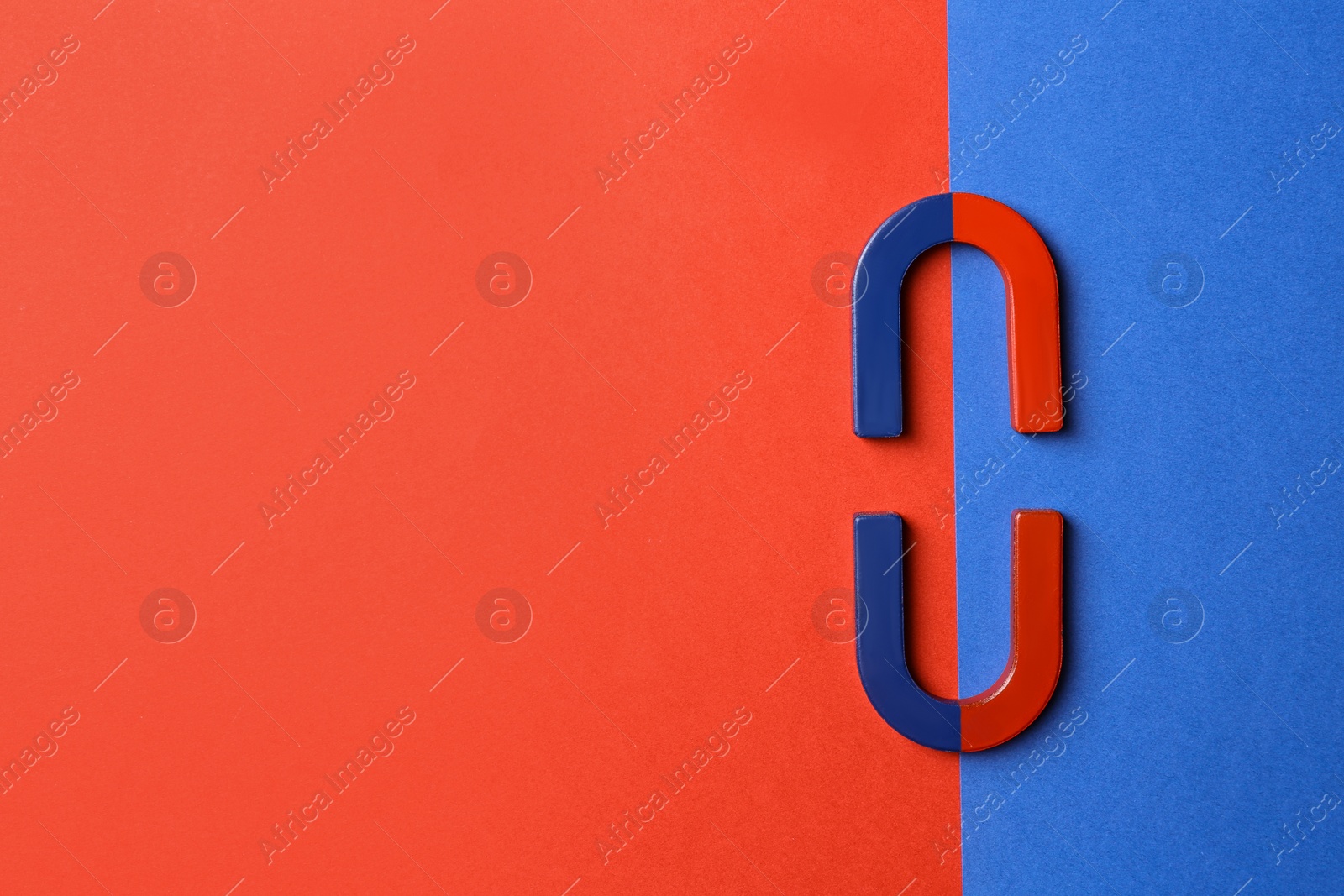 Photo of Red and blue horseshoe magnets on color background, flat lay. Space for text