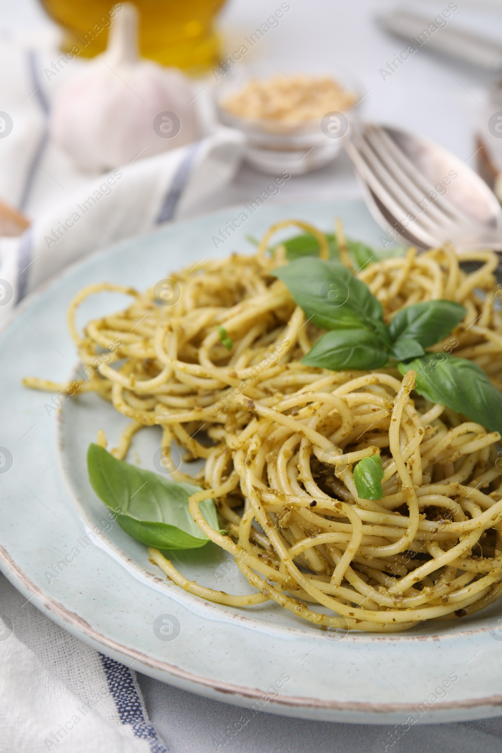 Photo of Delicious pasta with pesto sauce and basil on table, closeup